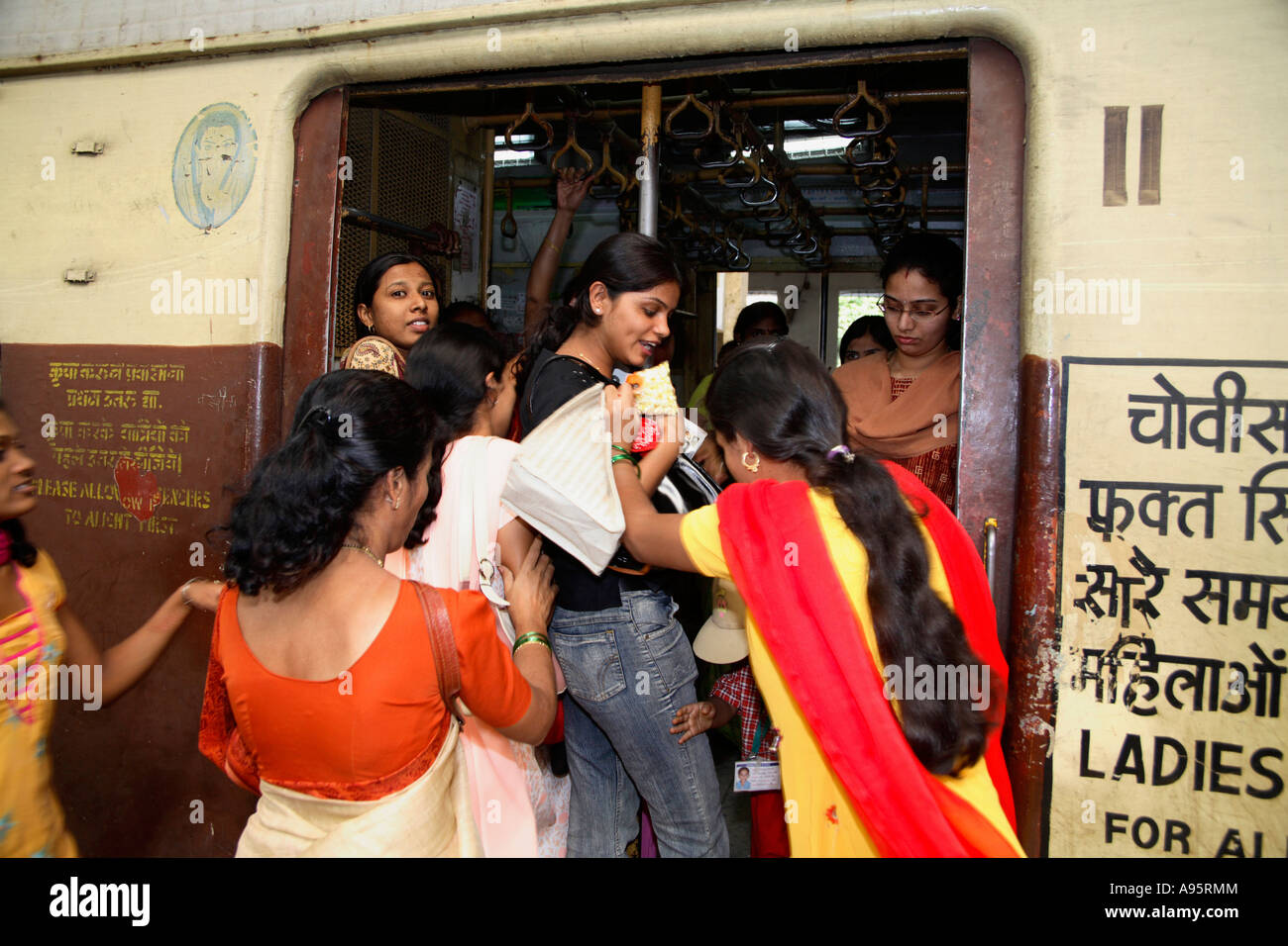 Le donne indiane lottano mentre si imbarcano in carrozza solo per Signore, Churchgate Railway Terminus, Mumbai, India Foto Stock