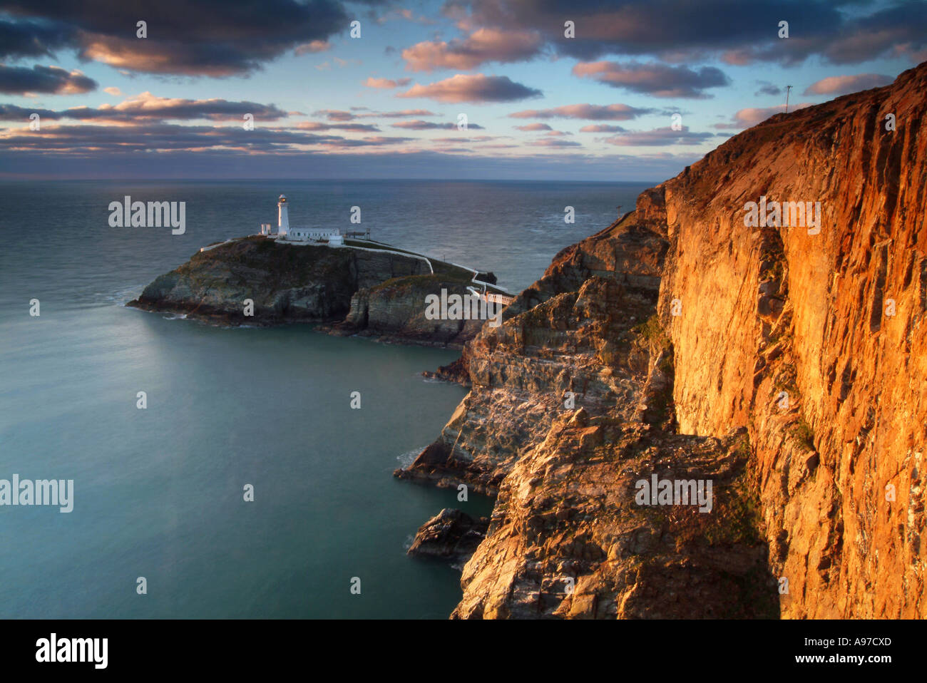 Serata della luce solare sullo stack del Sud, faro di Isola Santa, Anglesey, Galles del Nord, Regno Unito Foto Stock