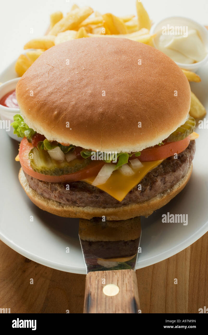 Cheeseburger con gli accompagnamenti sulla piastra FoodCollection Foto Stock