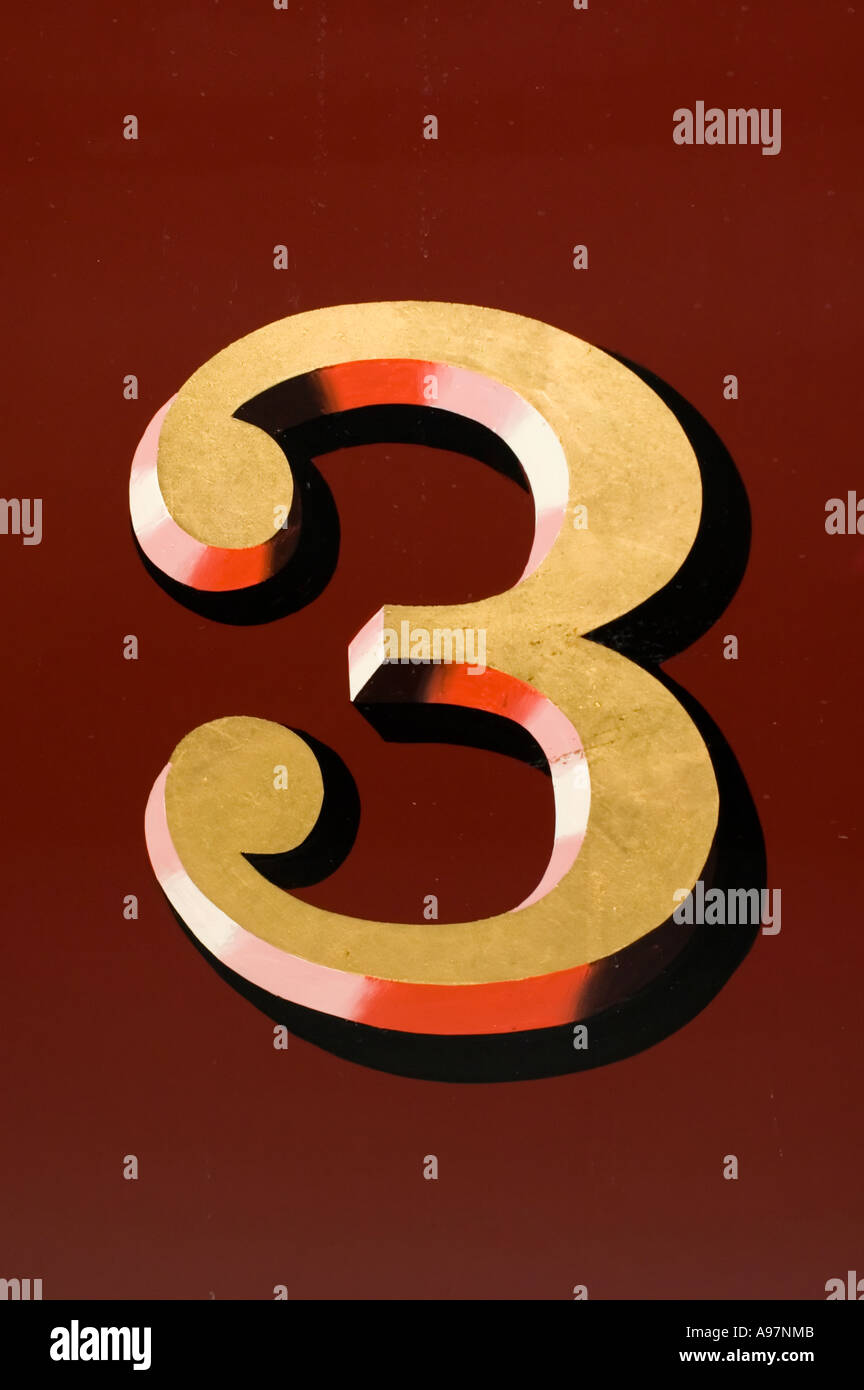 Giallo numero tre (3) su uno sfondo rosso Foto Stock