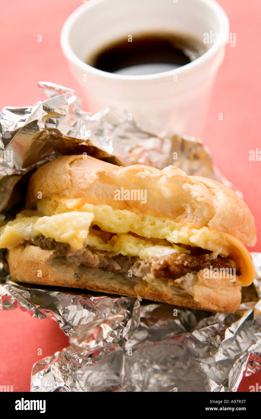 Cheeseburger con uova strapazzate un morso prese tazza da caffè FoodCollection Foto Stock
