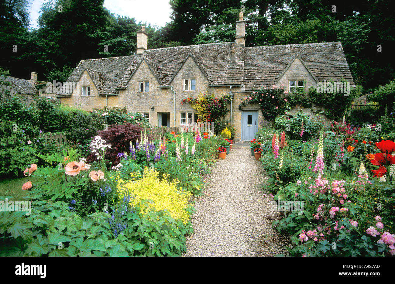 Cottage di antico e tradizionale inglese cottage gardens con fiori in estate Bibury village Gloucestershire Cotswolds Foto Stock