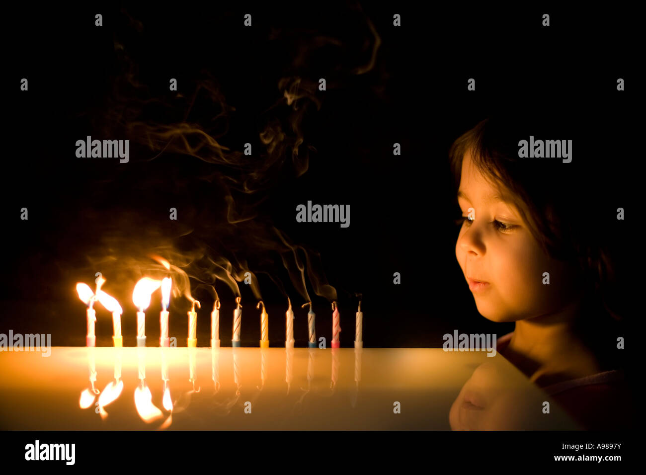 Ragazza di età compresa tra i 3 soffia out 12 candele Foto Stock