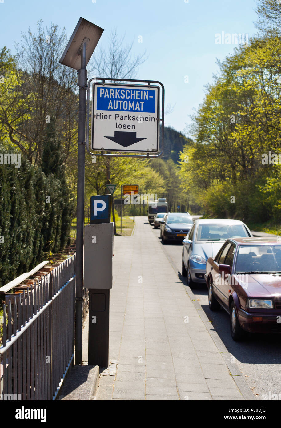 Contatore di parcheggio a energia solare con auto parcheggiate in strada all'interno della zona di parcheggio, Germania, Europa - 2007 Foto Stock