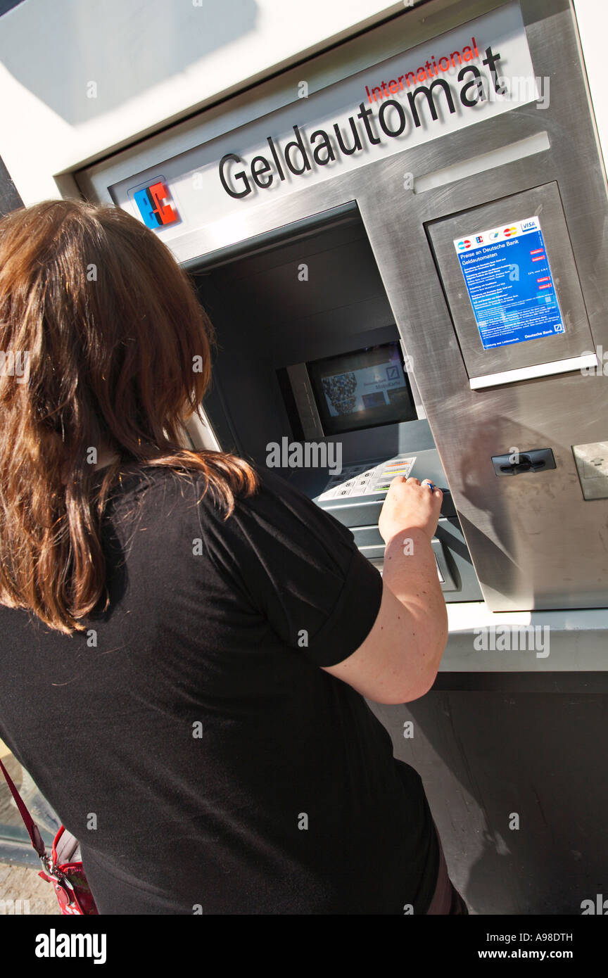 Donna che usa un bancomat tedesco Geldautomat Foto Stock
