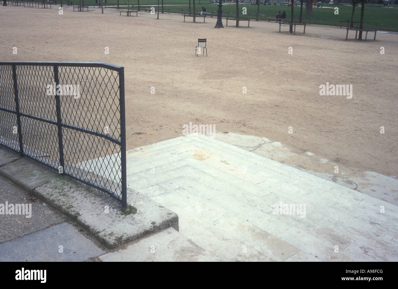 Una foto d'arte dei giardini Tuilerie a Parigi che mostra una sedia, alberi, un percorso e un recinto. Foto Stock