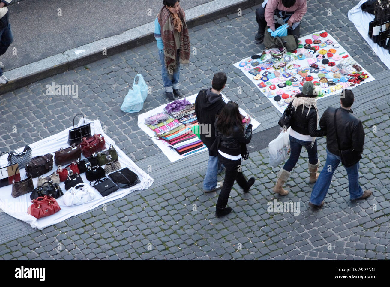 I turisti passano street trader con contraffazione di merci di designer in Roma, Italia Foto Stock