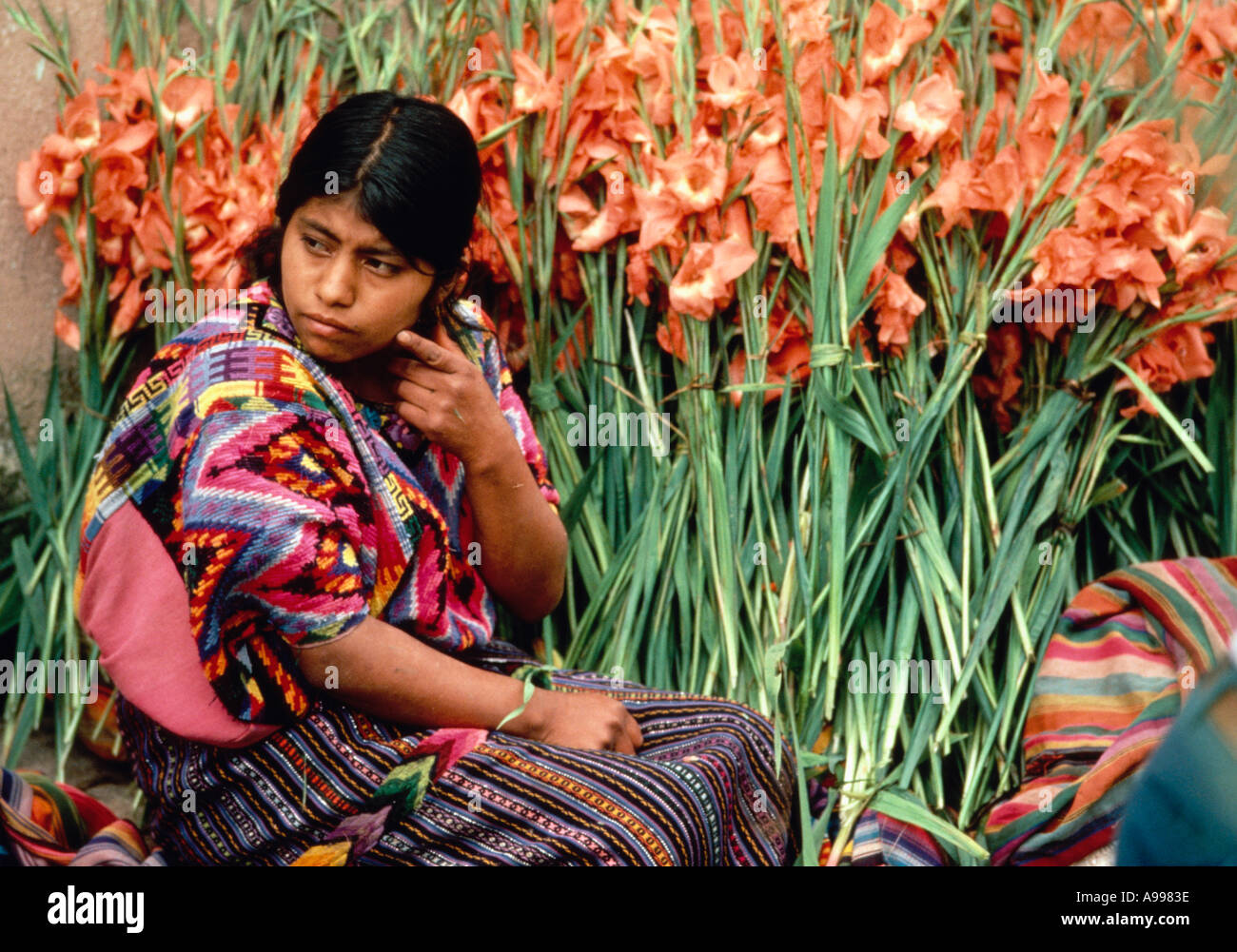 Guatemala giovane donna indiana in abito tradizionale vende fiori nel mercato nel villaggio di Chichicastenango Guatemala Foto Stock