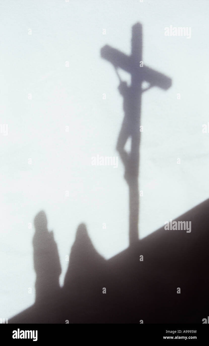 Ombra nella luce calda sul panno pallido o tenda di due donne in mantelli e il velo guardando a Gesù Cristo pendente sul crocifisso Foto Stock