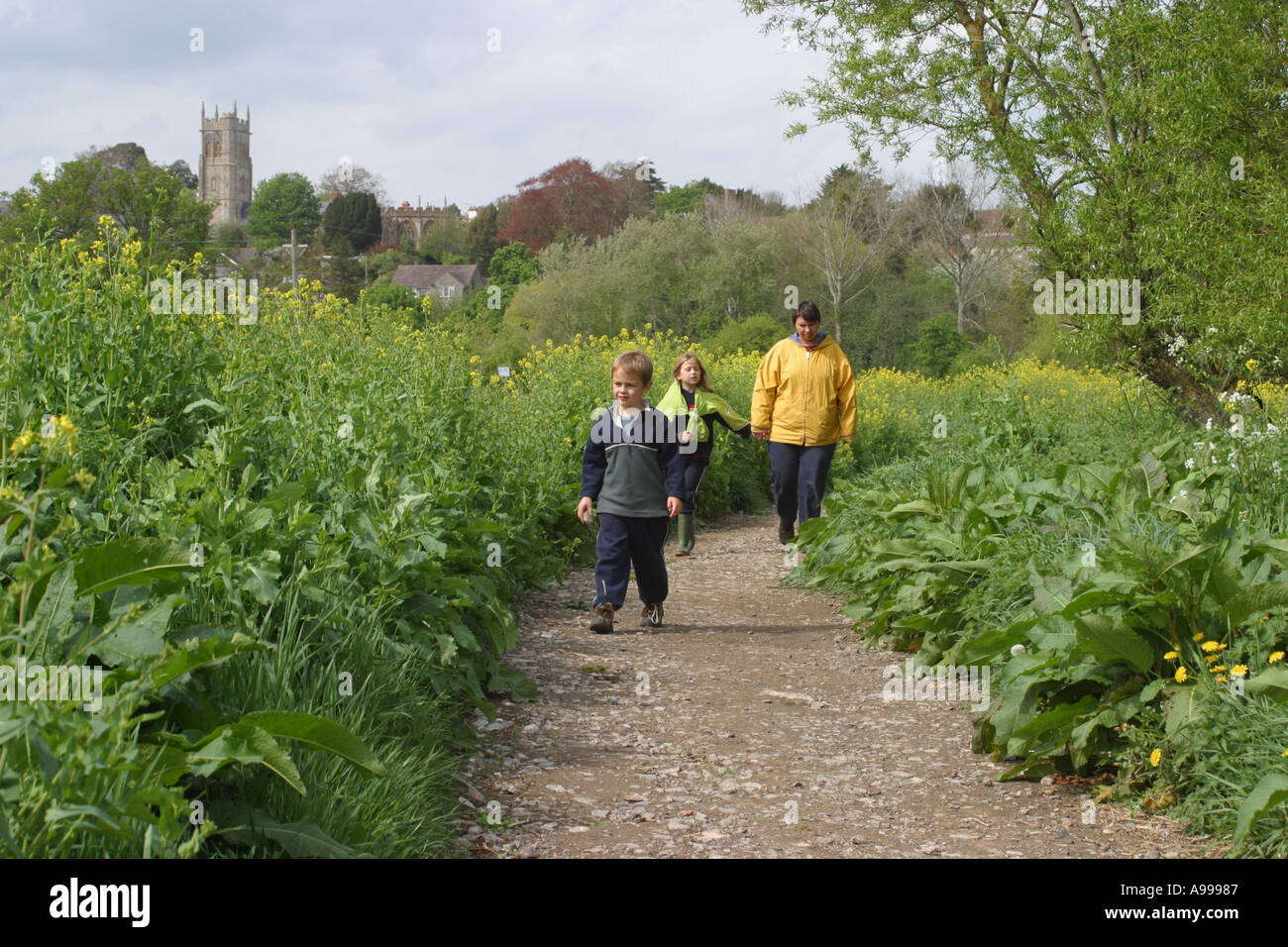 Famiglia camminare al fianco di incolto riverbank del Somerset livelli vicino Somerton Foto Stock