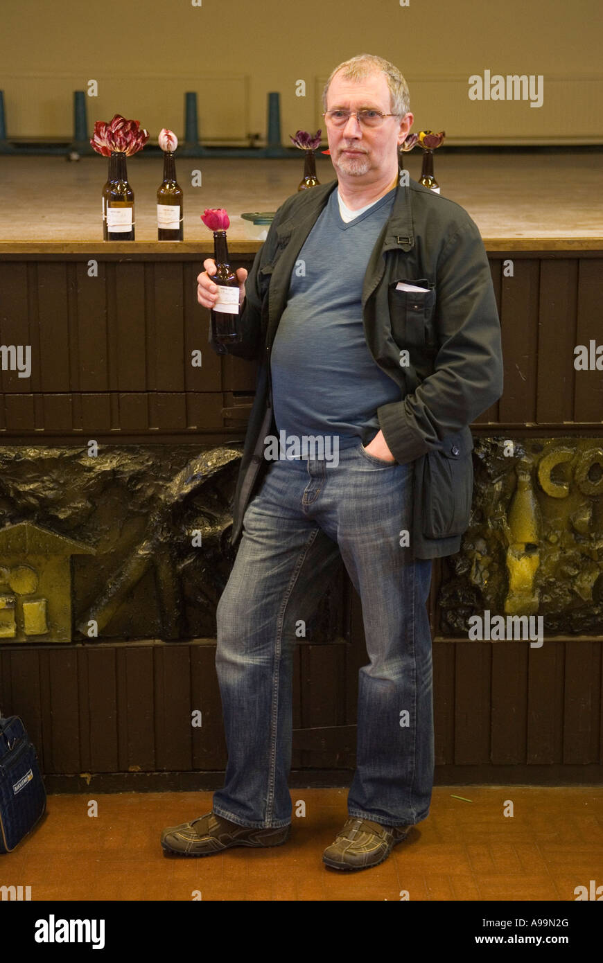 Coltivare tulipani di Bybloemen Tulips vecchio stile che tiene un ingresso alla competizione in una bottiglia di birra. Wakefield e North of England Tulip Society. Regno Unito anni '2000 Foto Stock