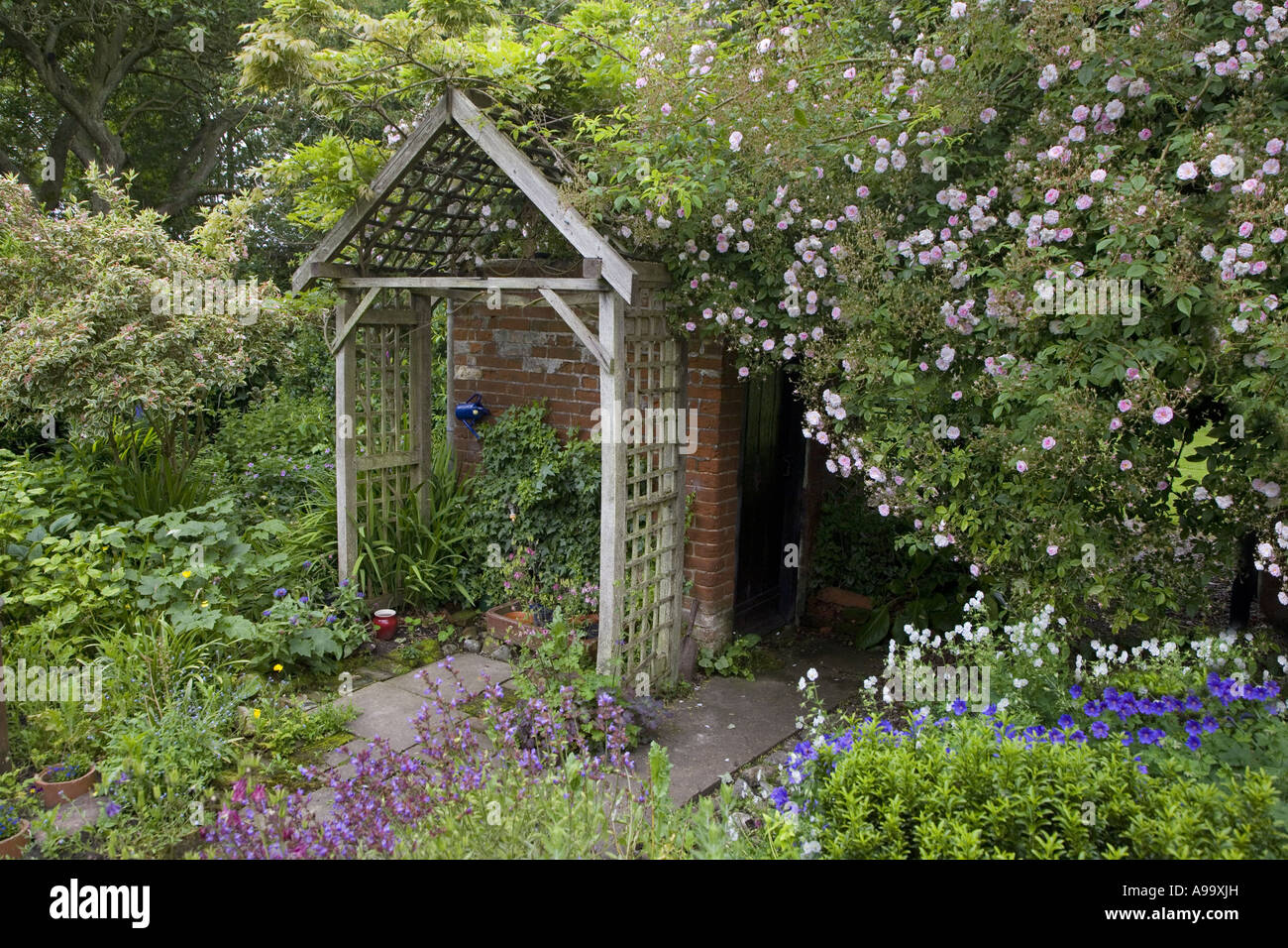 Giardino di casa a graticcio e letti di fiori Foto Stock