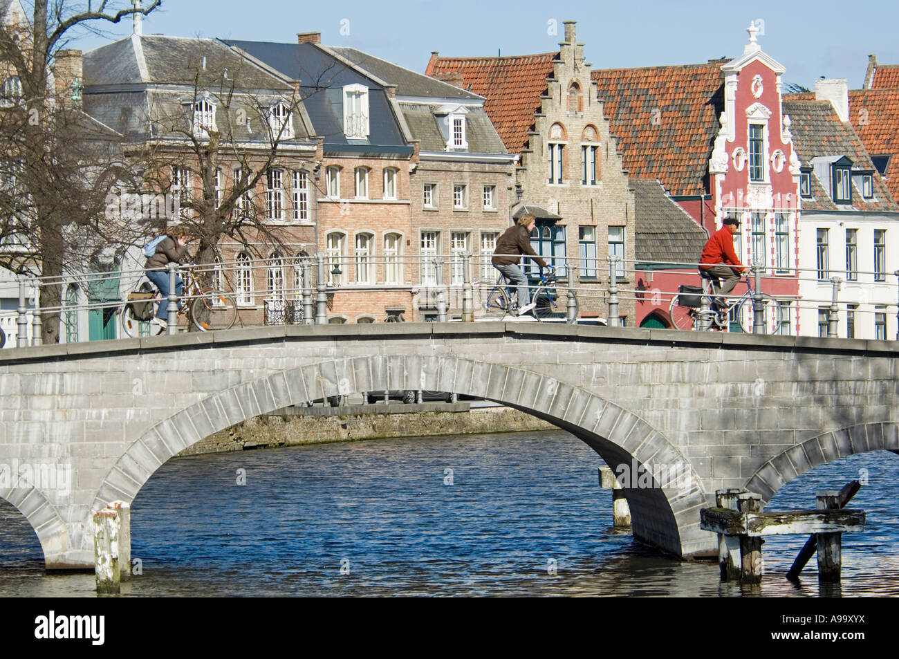 Due ciclista attraversando uno dei numerosi e pittoreschi ponti nella città vecchia di Bruges (Brugge), Belgio. Foto Stock