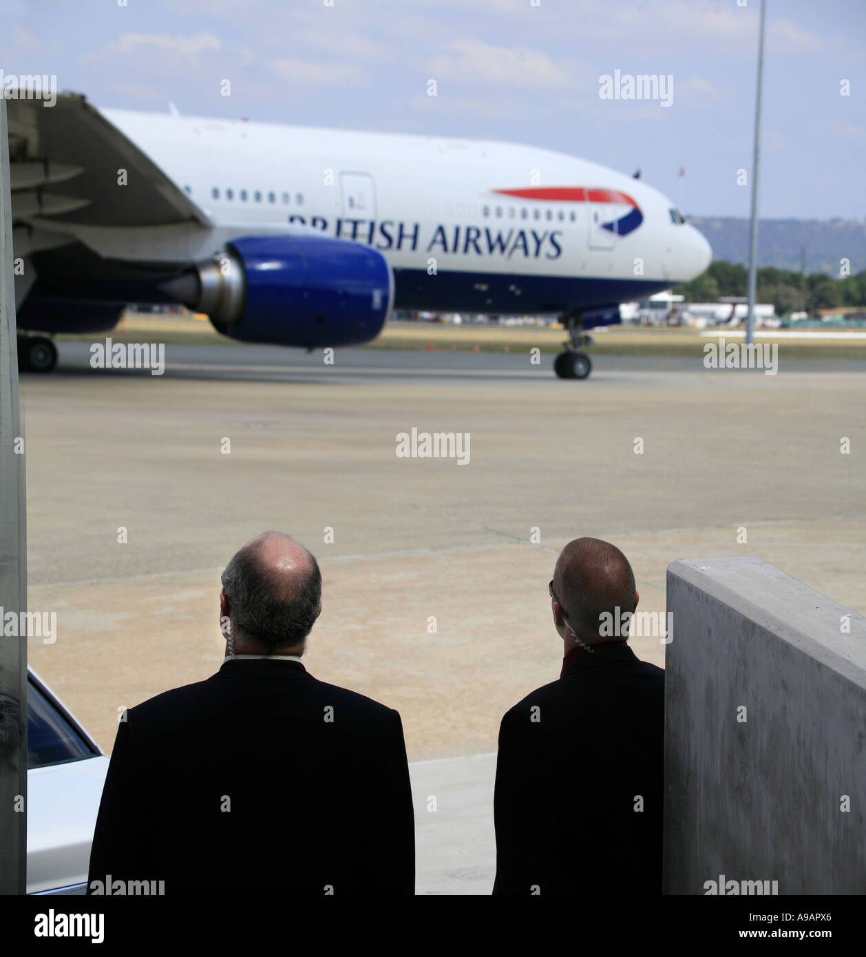 Servizio Segreto Britannico il personale guarda come un British Airways jumbo jet che porta la Sua Maestà la regina si diparte a Canberra in Australia Foto Stock