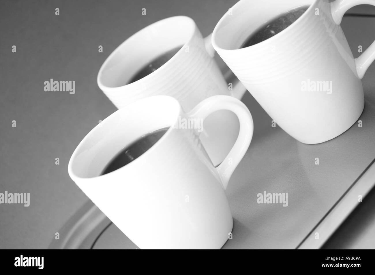 Nero caffè in tazze bianche sul vassoio d'argento, in bianco e nero Foto Stock