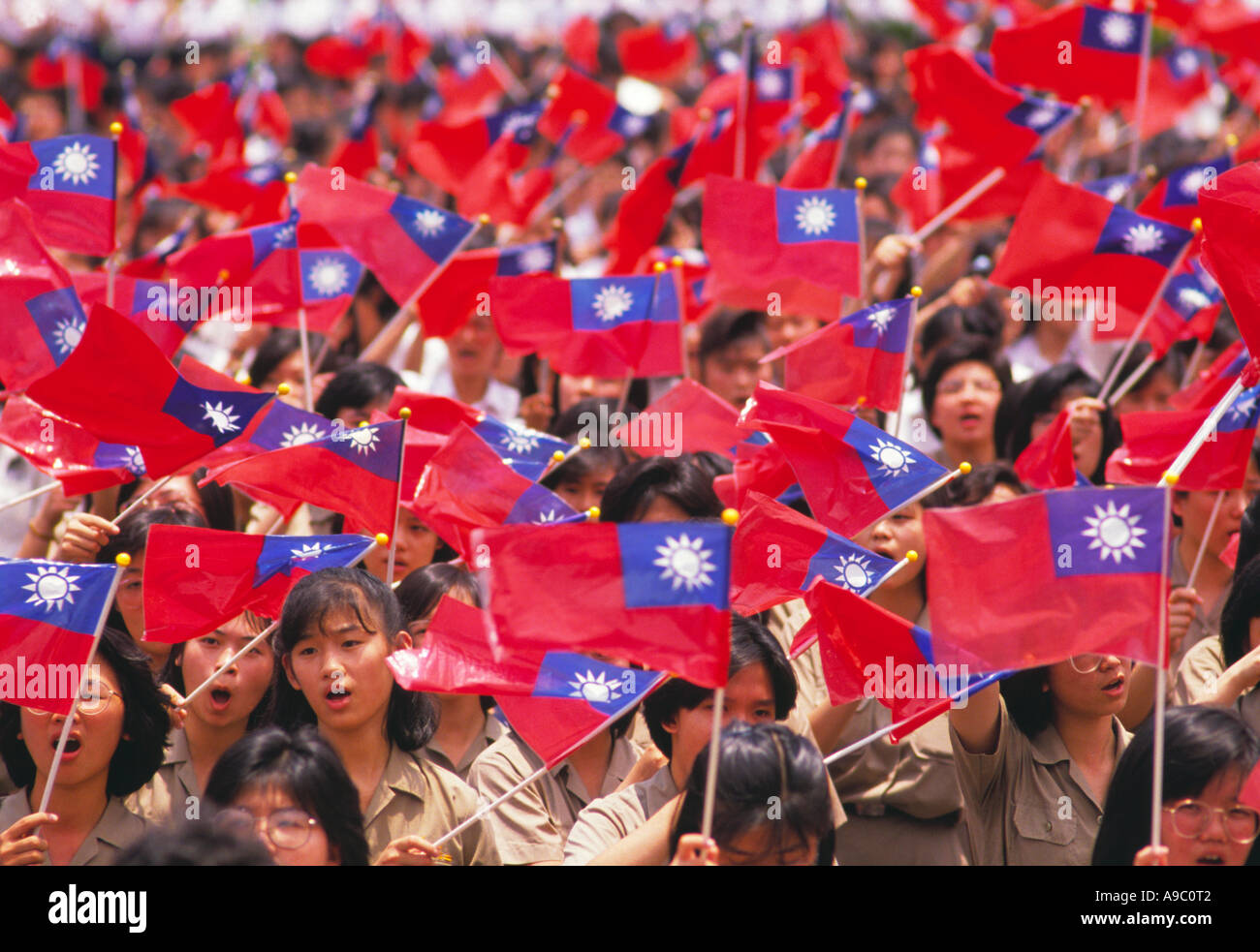 Gli alunni e gli studenti celebrano la Giornata nazionale sventolare la bandiera nazionale cantare canto nazionale Taipei Taiwan Foto Stock