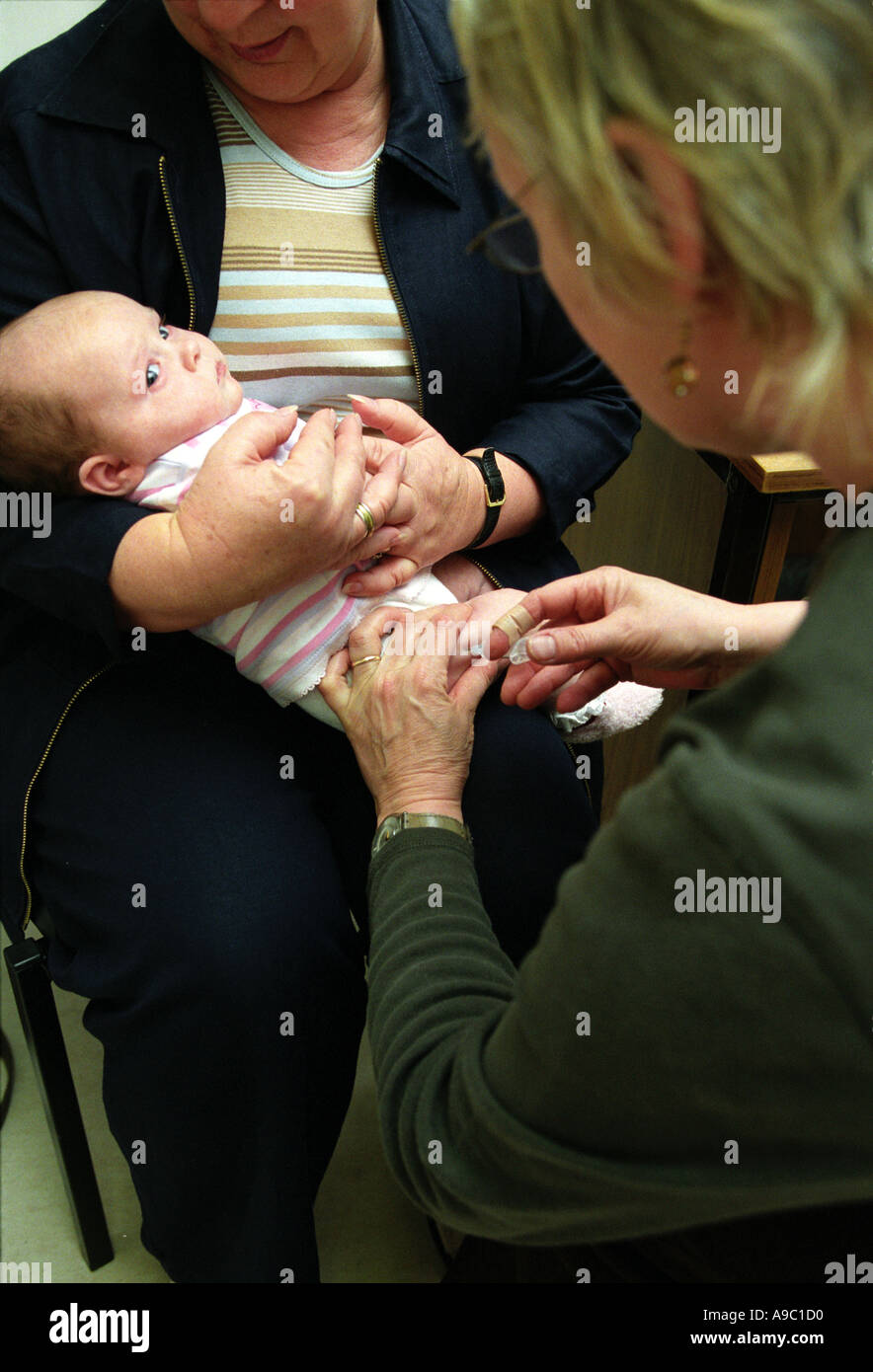 Otto settimane vecchio baby essendo dato il DTP immunizzazione da una pratica infermiera presso la clinica Foto Stock