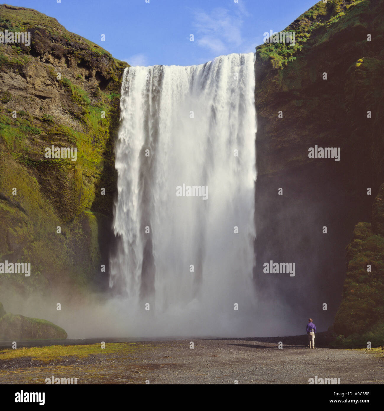Tenda come massa di acqua bianca si riversa sul bordo di una scogliera Skogafoss cascata Skogar Rangarvalla Islanda Foto Stock