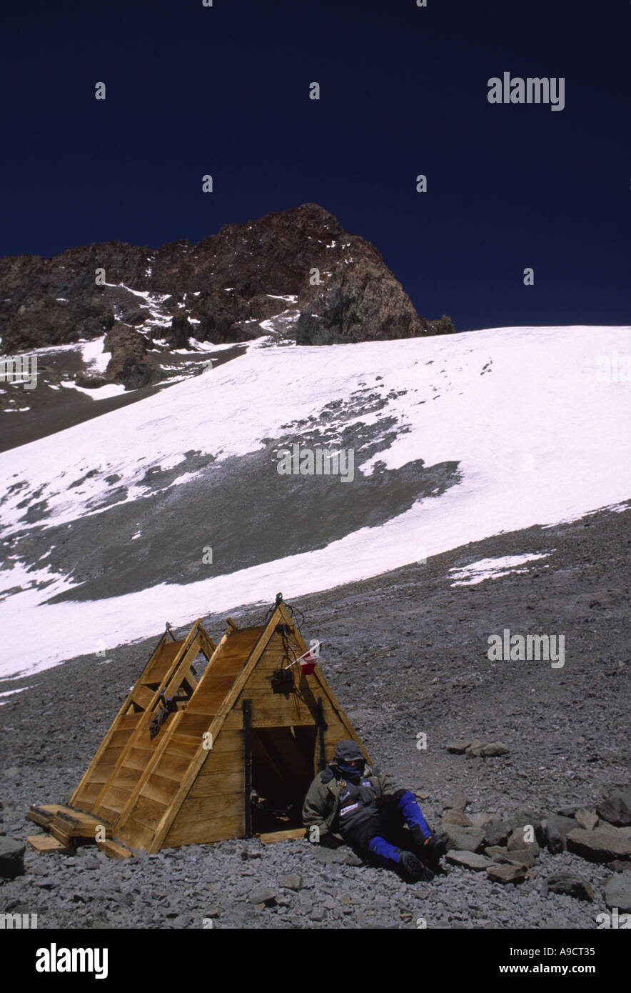 Un alpinista esausto si appoggia al Independencia rifugio a 6500 metri su Aconcagua Foto Stock