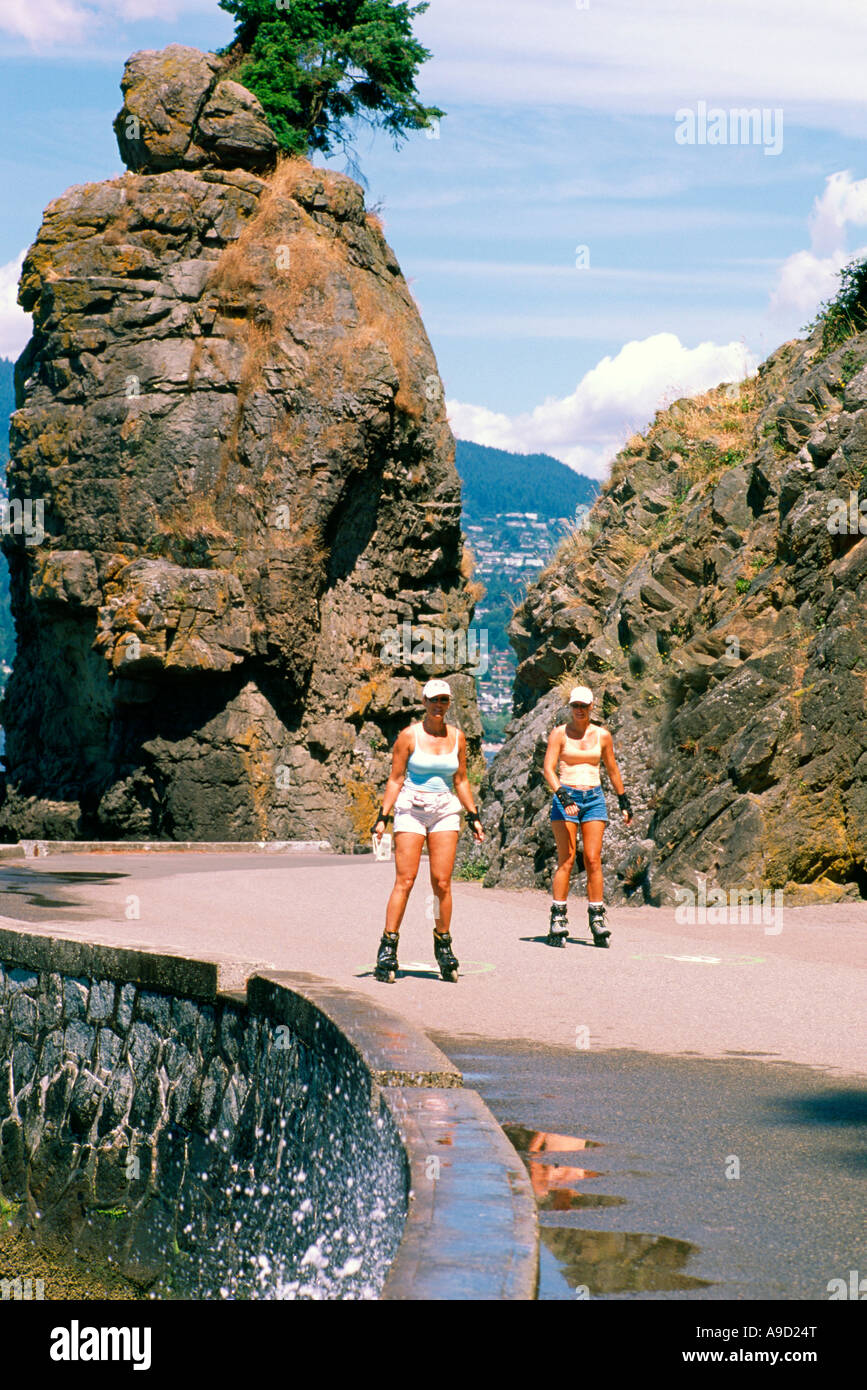 Le donne con i rollerblade lungo il Seawall a 'Siwash Rock' nel Parco di Stanley Vancouver British Columbia Canada in estate Foto Stock