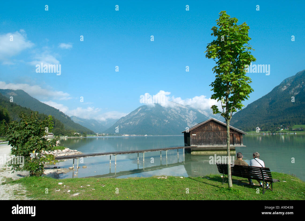 Coppia seduta su una panchina in riva al lago tra Maurach e Pertisau, Lago Achensee, Tirolo, Austria Foto Stock