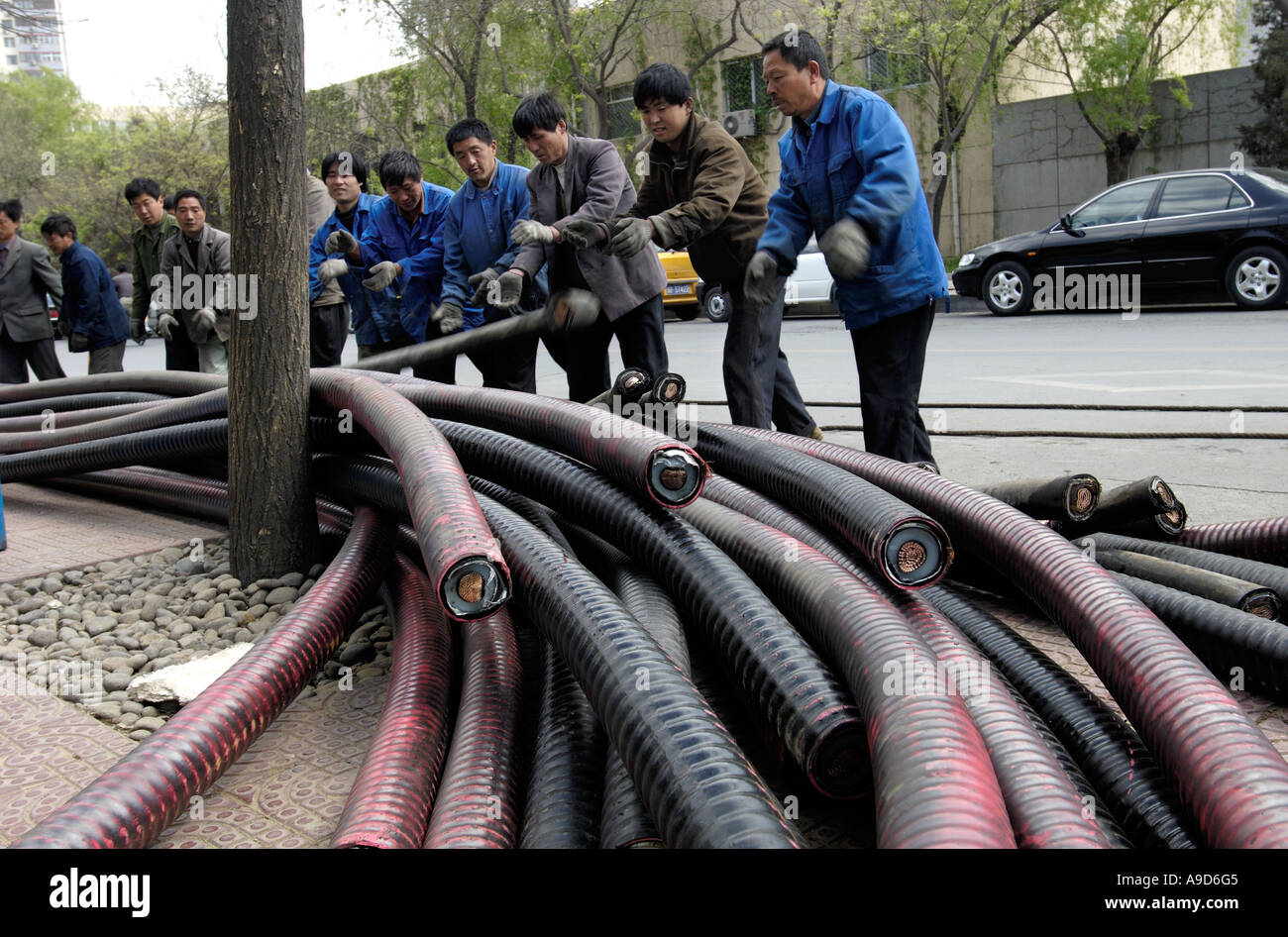 Lavoratori cinesi sostituire cavi elettrici su una strada a Beijing in Cina 19 Aprile 2006 Foto Stock