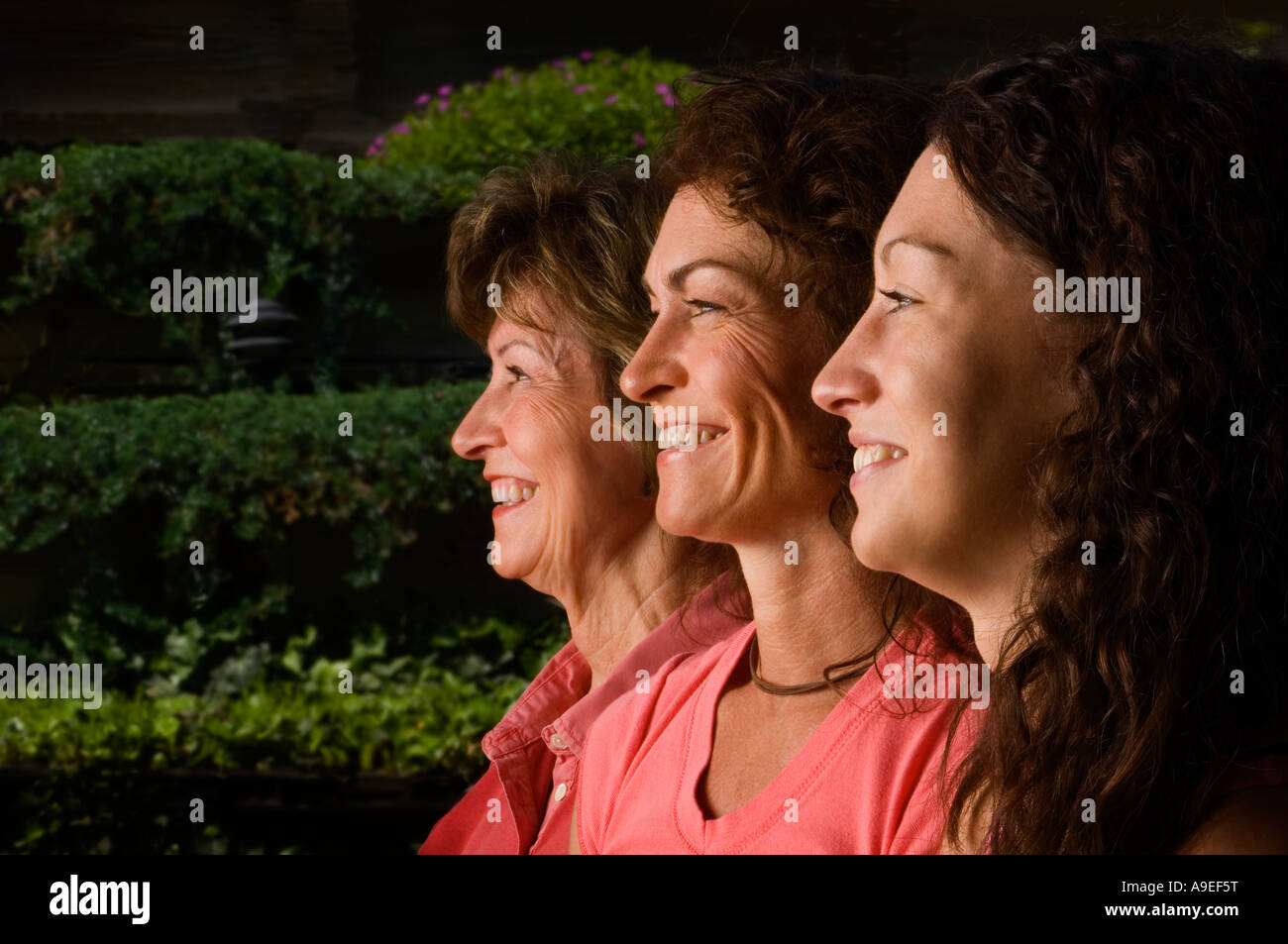 Tre generazioni di donne profilo sorridente alla fotocamera Foto Stock