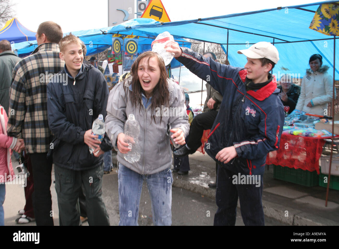 Gli adolescenti gettare acqua a ogni altro presso la fiera di Emaus Cracovia Polonia Foto Stock