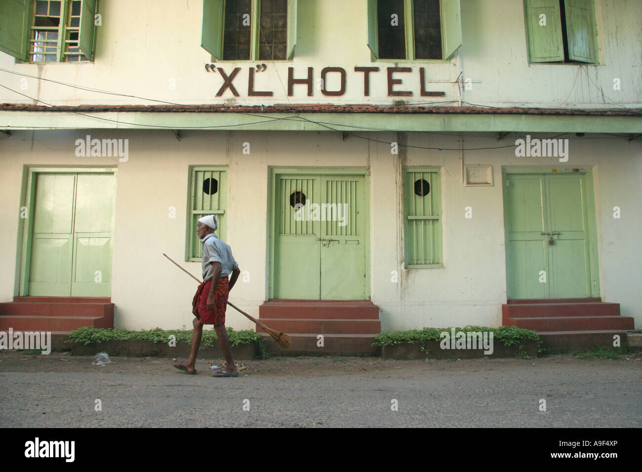 Un pulitore di via al di fuori del "XL" Hotel in Fort Kochi (Cochin), Kerala, India del Sud Foto Stock
