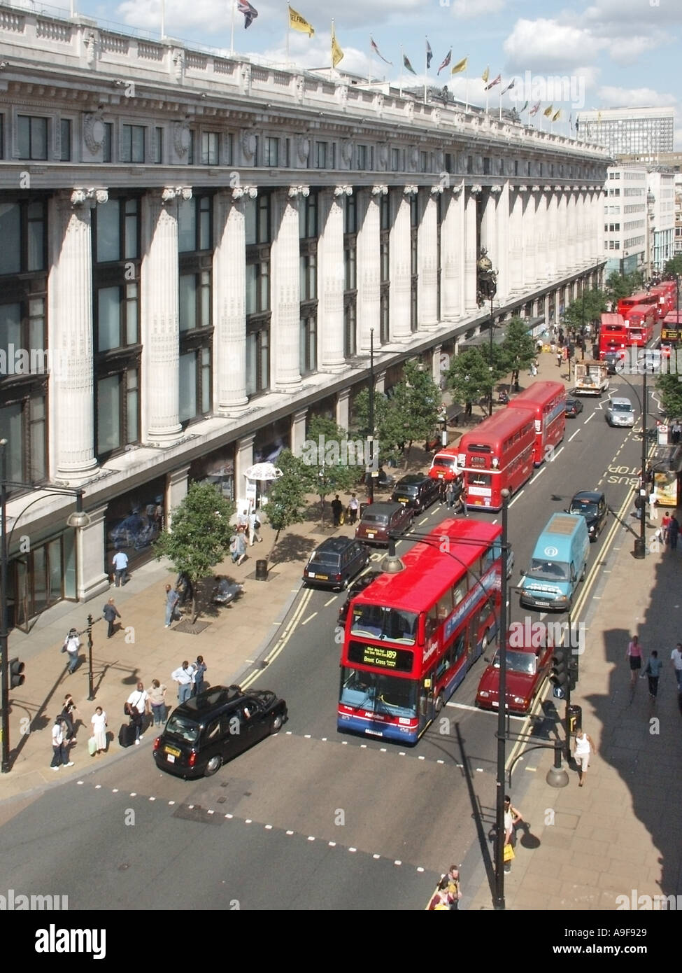 Vista aerea guardando giù occupato da Oxford Street e dal grande magazzino Selfridges colonnade & shoppers London red double decker bus West End England Regno Unito Foto Stock