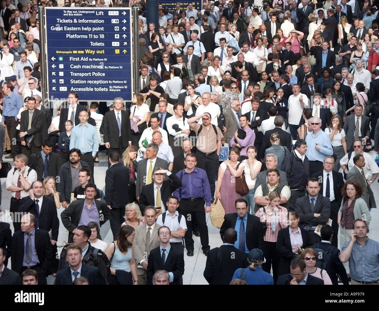 Viaggiatore caos & interruzioni a Liverpool Street Stazione ferroviaria treni pendolari passeggeri in attesa & cercando fino alla partenza delle schede per informazioni REGNO UNITO Foto Stock