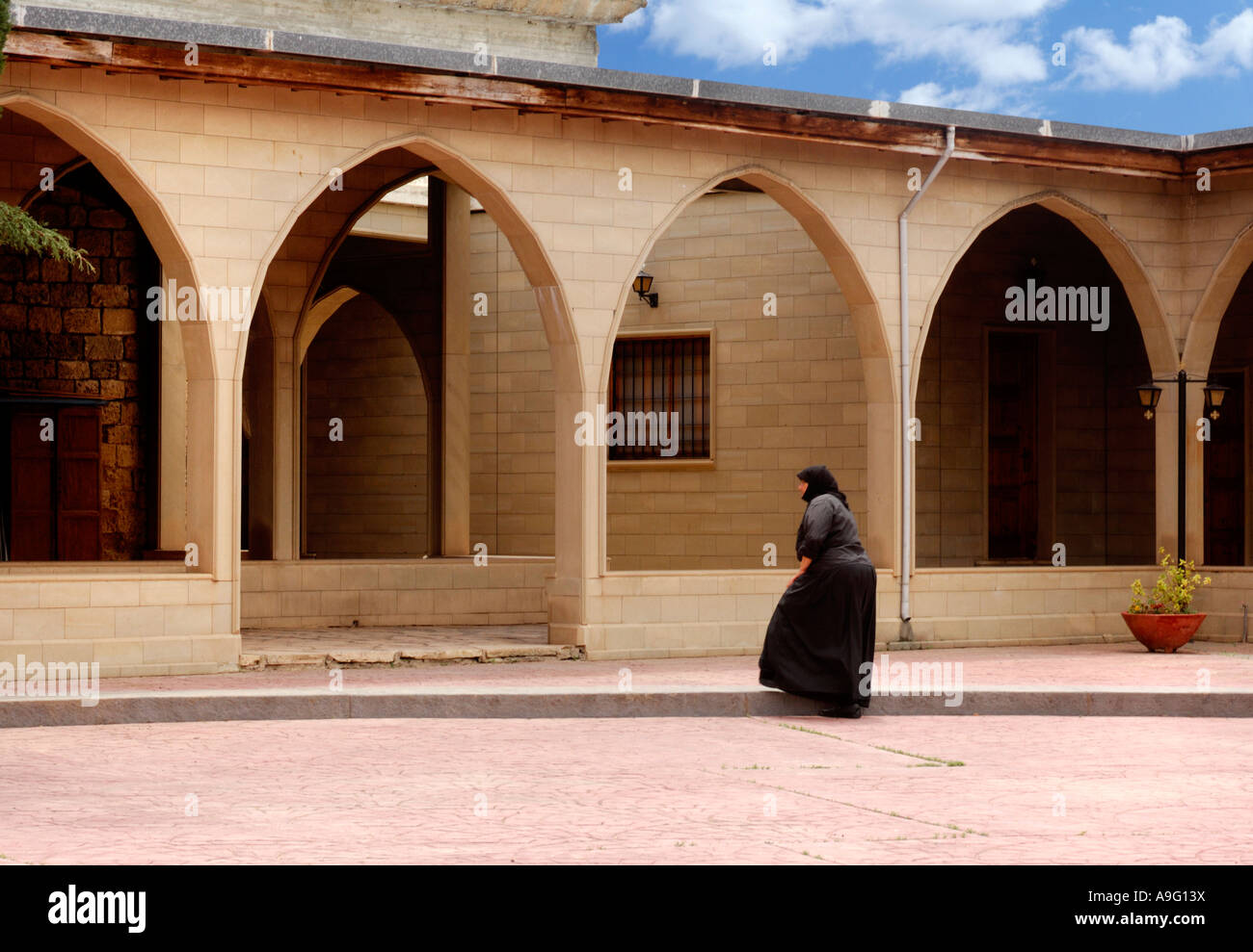 Suora in una tonaca nera entrando in Saint Nicolas monastero monastero culto religioso adoratore Foto Stock