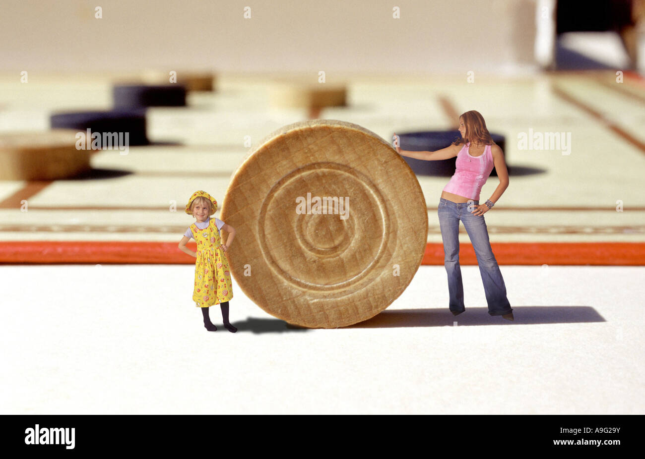 Donna e bambina in piedi di fronte a un gigantesco Checkers board game Foto Stock