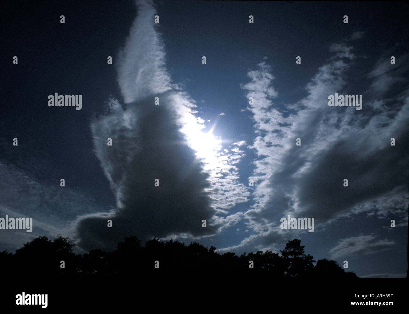 Tempesta di nuvole sole splendente di luce da dietro le nuvole Cumulonimbus Foto Stock