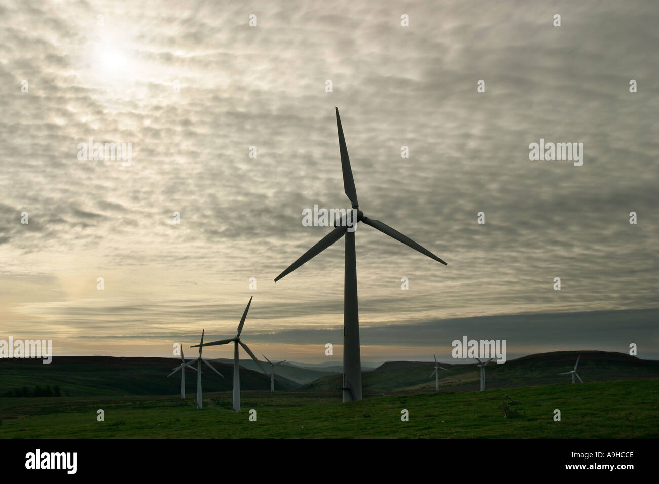 Il potere di vento turbine che producono energia elettrica su una collina, il Galles Centrale, al crepuscolo Foto Stock