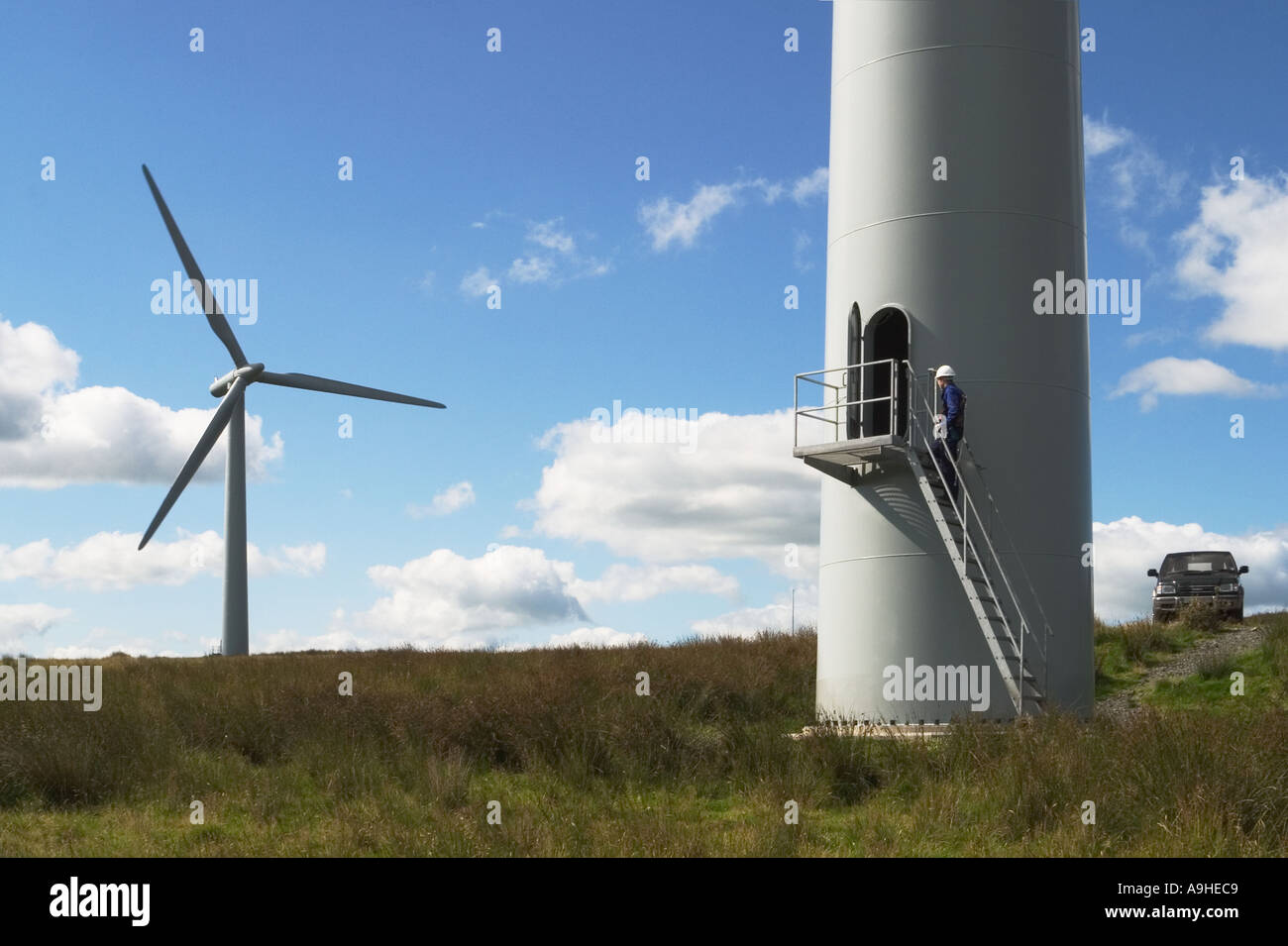 Ingegnere di passaggi di arrampicata a torre per controllare e mantenere il potere di vento turbina che produce elettricità per parte di Cumbria Regno Unito a Lambrigg Wind Farm Foto Stock
