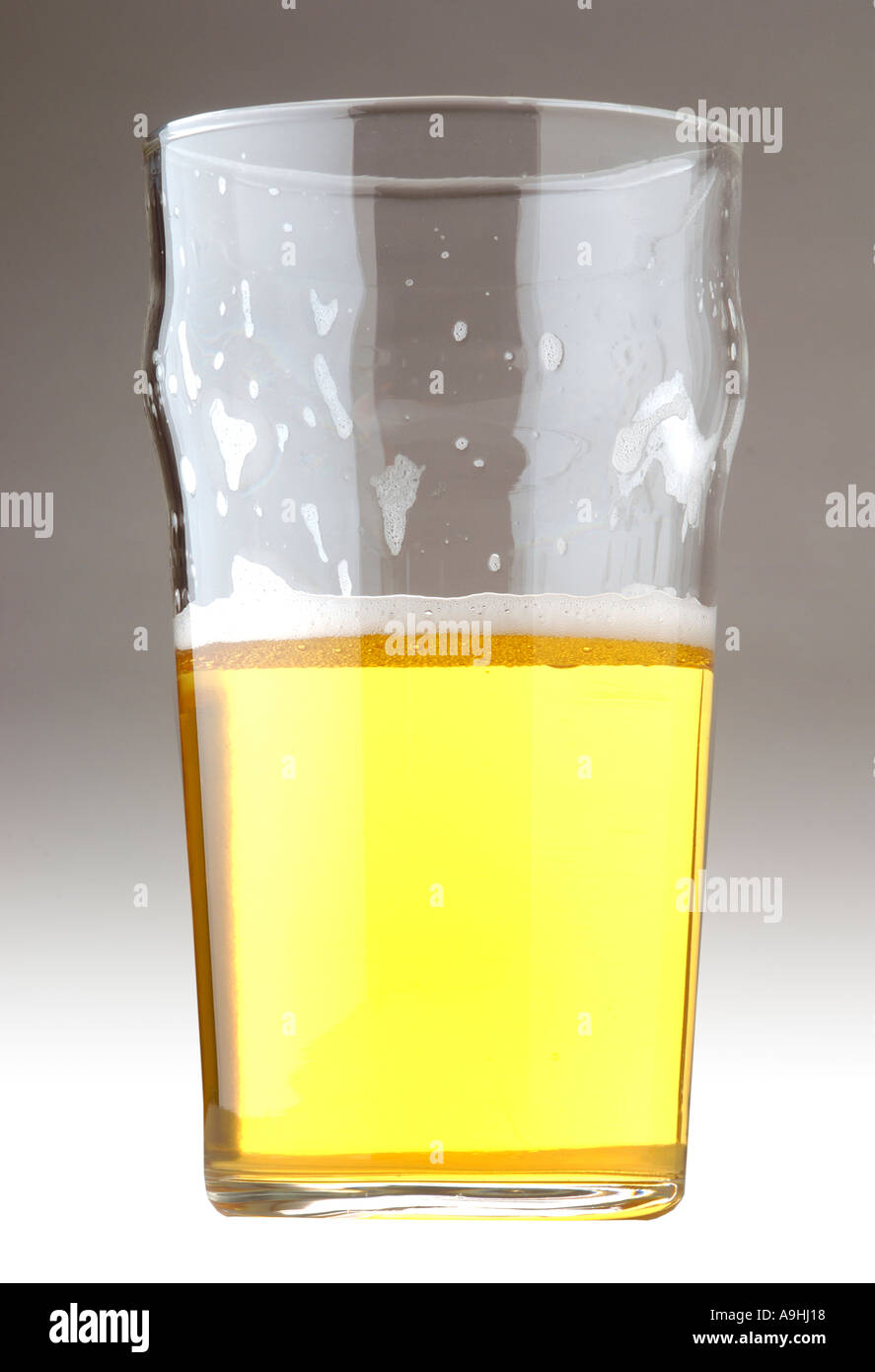 Mezza pinta piena bicchiere di birra lager Foto Stock