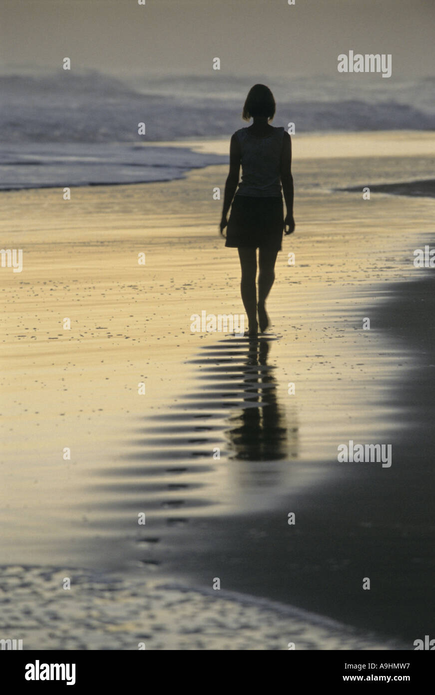 Donna che cammina sulla spiaggia, Knysna Foto Stock