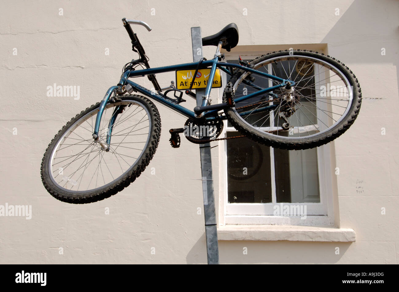 Un Raleigh Mountain bike è fissato sulla parte superiore di un parcheggio  polo di restrizione su una strada della città Foto stock - Alamy