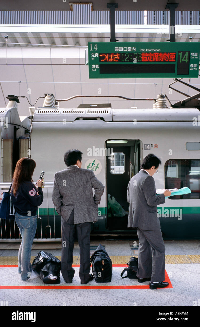 Pendolari attendere per la partenza del loro Shinkansen con il treno alla Stazione di Tokyo. Foto Stock