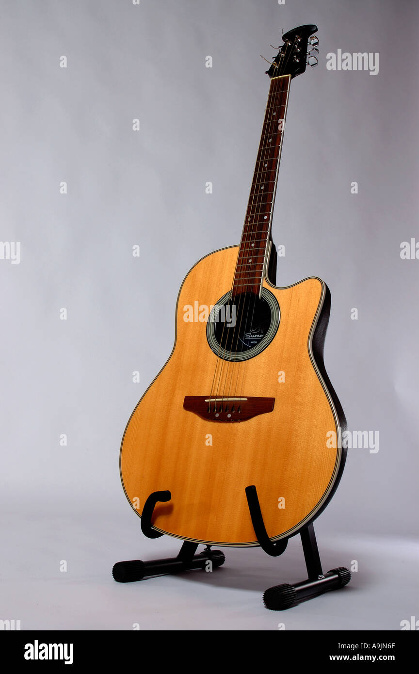 Electro chitarra acustica su un cavalletto fotografati contro un bianco  colorama Foto stock - Alamy