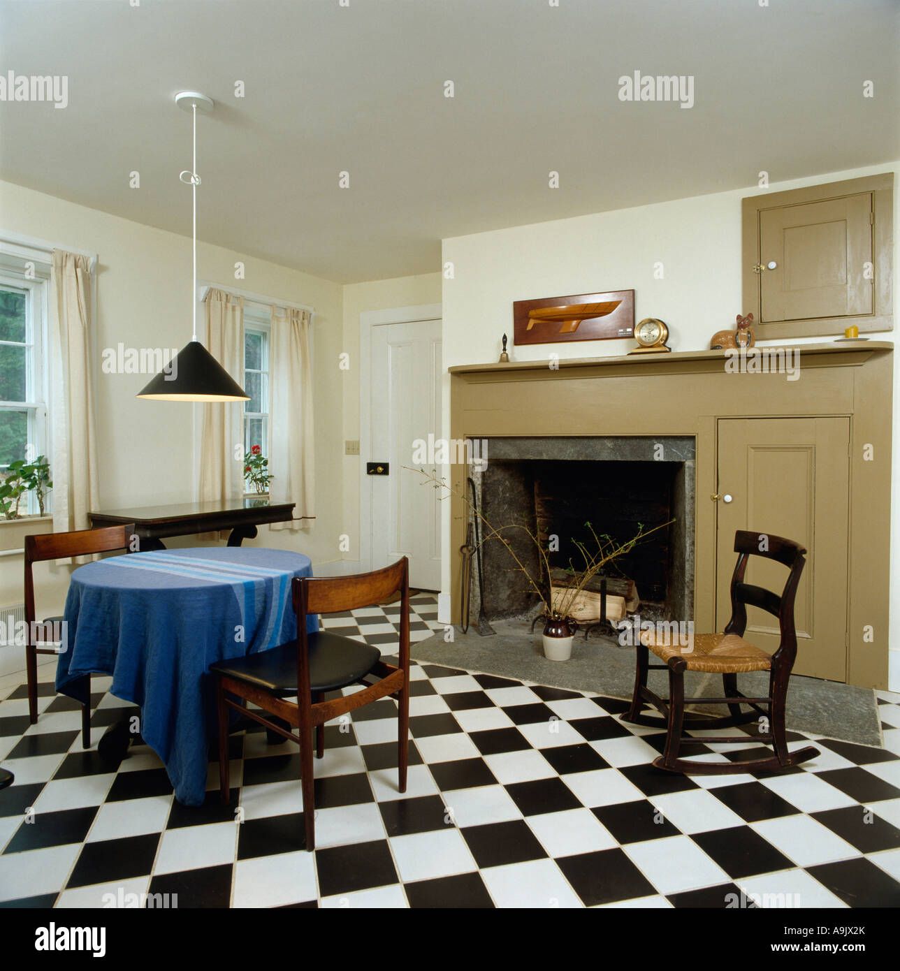 Bianco e nero chequerboard pavimentazione in bianco e sala da pranzo con caminetto beige Foto Stock
