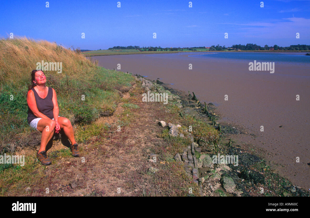 Donna godendo il sole Butley fiume creek Suffolk in Inghilterra Foto Stock