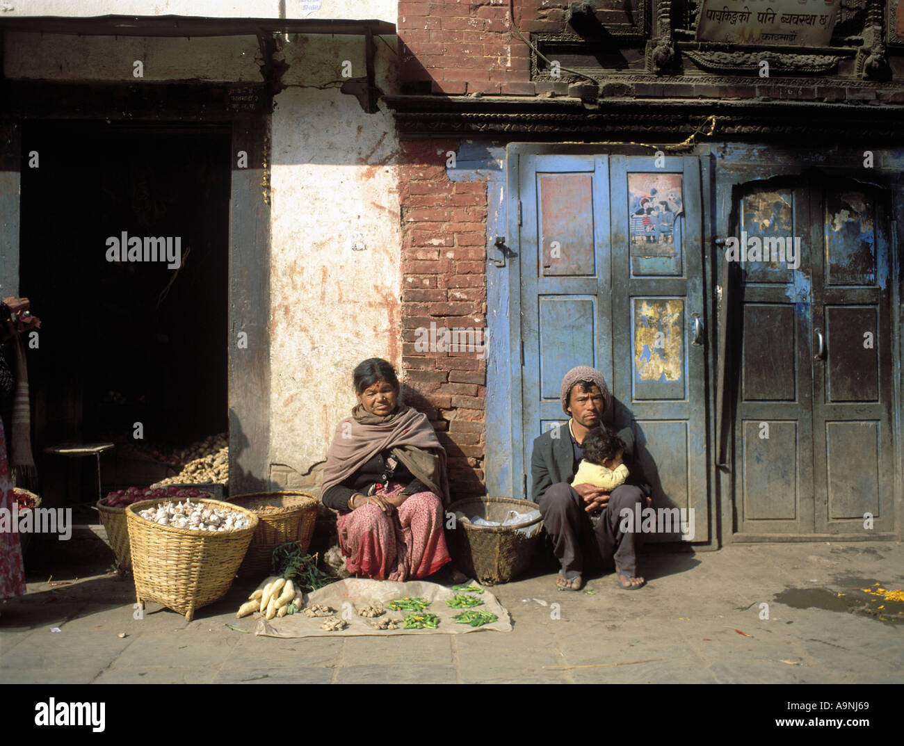 Pressione di stallo di strada sulla piazza Durba a Katmandu Nepal vendere verdure contro l edificio abbandonato Foto Stock