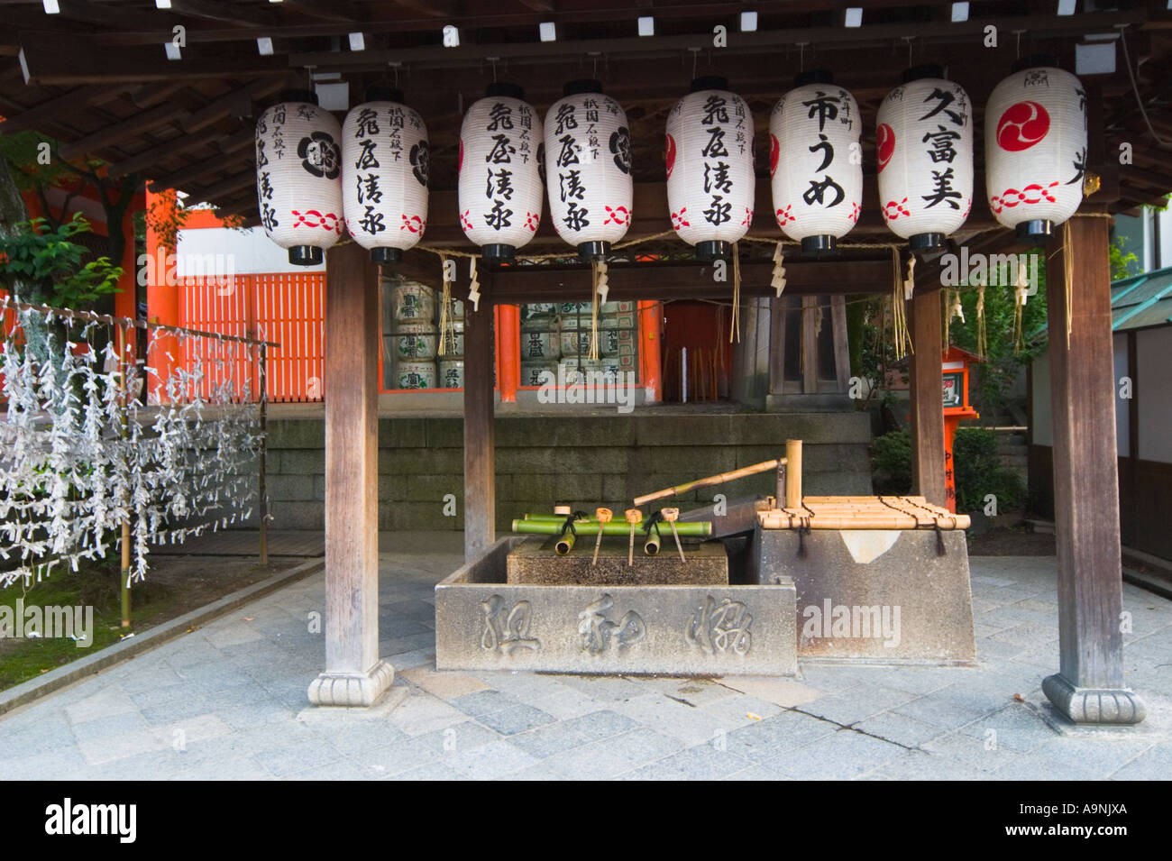 Lanterne di carta appeso dal gazebo oltre la fontana purfication presso il santuario Yasaka Kyoto la regione di Kansai Giappone Foto Stock