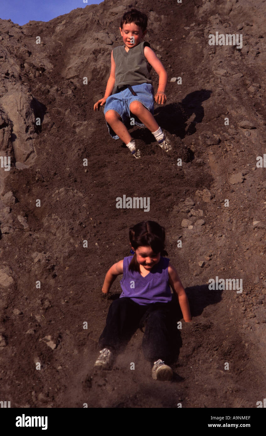 I due ragazzi far scorrere verso il basso un sandpile in Portland o Foto Stock