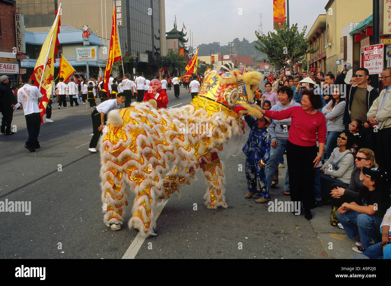 Donna che nota A 'Lion' durante il Capodanno cinese anni sfilano in Los Angeles Chinatown Foto Stock