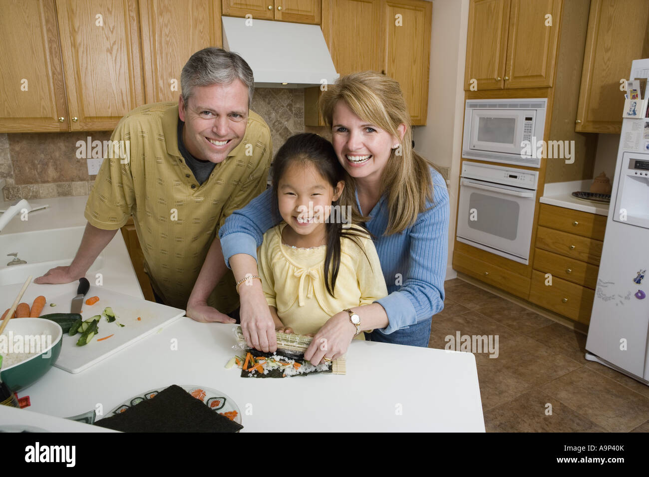Ritratto di una famiglia in cucina rendendo sushi Foto Stock