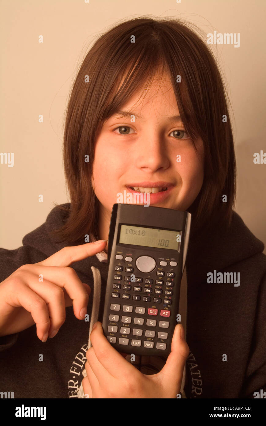 Giovane ragazzo dai capelli lunghi con calcolatrice scientifica di vecchio stile Foto Stock