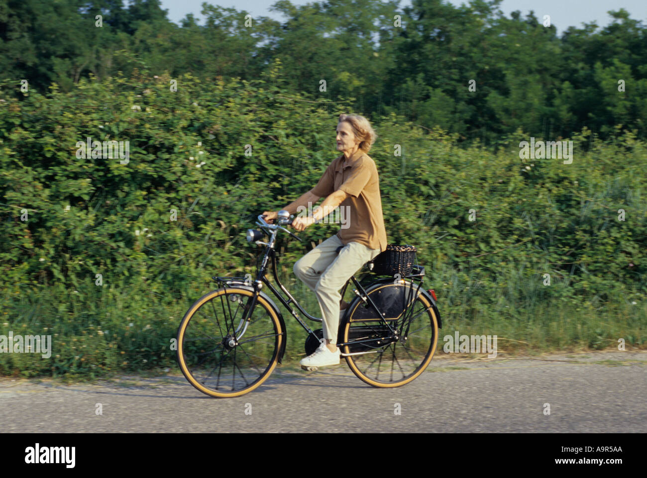 Il Lido di Venezia, Italia. Donna nella sua 70' a cavallo di un bicycl. Foto Stock